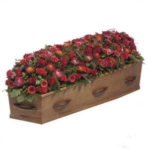 kist rouwwerk rode bloemen uitvaart